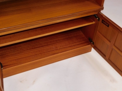 A Nathan teak bookcase, with five shelves, over a pair of panelled cupboard doors, enclosing a further shelf, raised on a plinth base, 57.5cm high, 84cm wide, 34cm deep. - 3