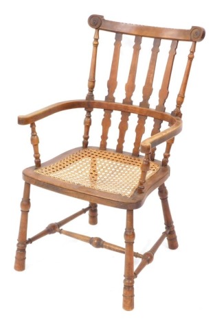 A Victorian oak and elm country armchair, with a cane seat, raised on turned legs, united by a turned H framed stretcher.