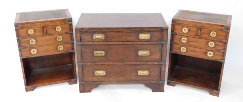 An oak military chest, of three long graduated drawers, raised on bracket feet, 61cm high, 75cm wide, 40cm deep, together with a pair of bedside chests, each having a tooled leather top, brushing slide, two short over two long drawers above a recess, rais