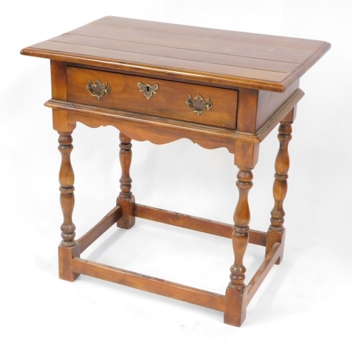 A 17thC style walnut side table, with a four plank top, over a frieze drawer, shaped apron raised on baluster turned columns united by a boxed stretcher, 52cm high, 74cm wide, 49cm deep.
