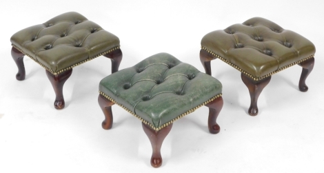 Three button back green leather footstools, raised on cabriole legs, each 31cm wide. The upholstery in this lot does not comply with the 1988 (Fire & Fire Furnishing) Regulations, unless sold to a known exporter or upholsterer it will be cut from the fra