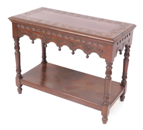 An Old Charm style oak rectangular coffee table, with carved sunburst decoration to top on frieze, raised on turned legs, united by an under tier, 70cm high, 91cm wide, 45cm deep.