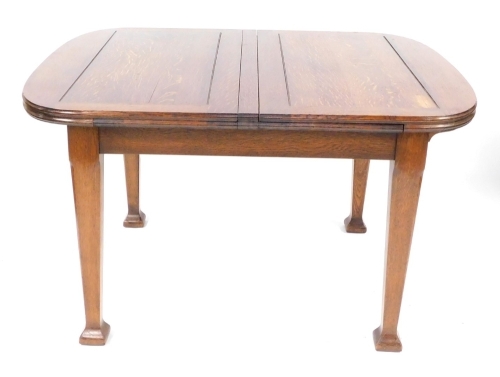 An early 20thC oak draw leaf dining table, raised on tapering square legs and block feet, 74cm high, 77cm wide, 194cm extended, 102cm deep.