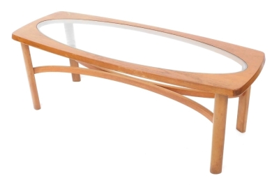 A mid century teak coffee table, inset oval glass, raised on turned legs united by a curved X framed stretcher, 54cm high, 120cm wide, 44cm deep.