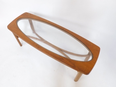 A mid century teak coffee table, inset oval glass, raised on turned legs united by a curved X framed stretcher, 54cm high, 120cm wide, 44cm deep. - 2