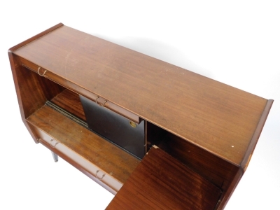 A G-Plan 1950's teak sideboard, with a single drawer above two ebonised sliding doors enclosing a drinks cabinet, flanked by a dropped down cabinet, over one long and one short drawer, raised on ebonised legs, brass capped, 76cm high, 121cm wide, 48cm dee - 2