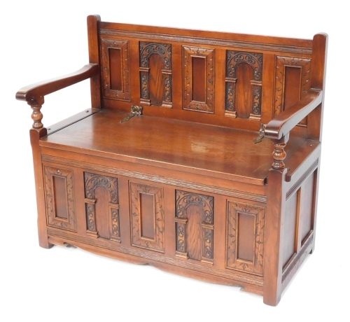An Old Charm style settle, with a five panel back and pewter Art Nouveau style hinges, on a box base, 85cm high, 97cm wide, 50cm deep.