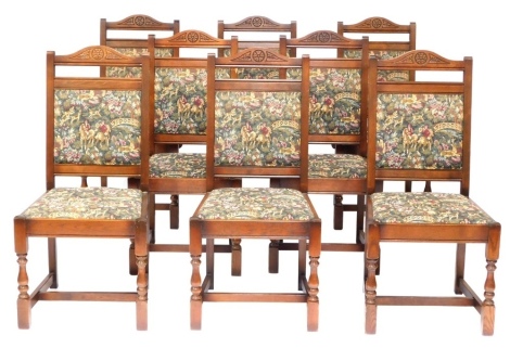 A set of eight oak dining chairs, each with tapestry seats, comprising two carvers, 104cm high, 50cm wide. The upholstery in this lot does not comply with the 1988 (Fire & Fire Furnishing) Regulations, unless sold to a known exporter or upholsterer it wi