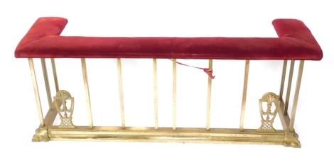 A 19thC brass club fender, with red velvet top on brass supports with fan design, 53cm wide, 136cm wide, 40cm deep.