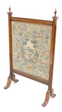 A carved oak tapestry firescreen, with finial tops, with a pleated and beaded border, the panel depicting male and female seated, 128cm high, 75cm wide.