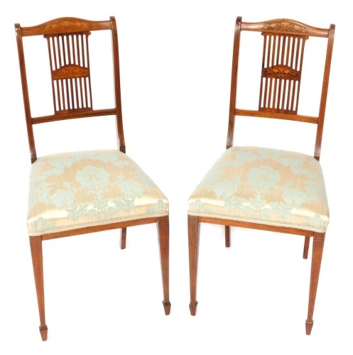 A pair of Edwardian rosewood chairs, each with a marquetry floral panel back, on turquoise and silver upholstered seats.