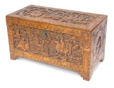 An early 20thC camphorwood chest, with carved oriental figures, central buckle, opening to reveal light out shelf, 59cm high, 105cm wide, 52cm deep.