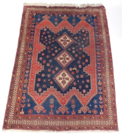A Persian Afshar rug, with a three cream lozenges on a blue ground, within a shaped border, geometric blue spandrels within multiple borders, 228cm x 160cm.