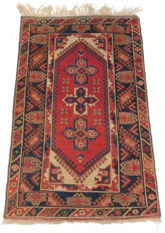 A Persian rug, decorated with three star shaped medallions on a red ground, with cream spandrels and one wide and two narrow borders, 120cm x 210cm.