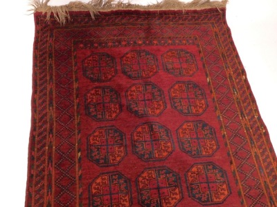 A Belouch rug, with three rows of medallions, on a red ground, with multiple borders, 124cm x 244cm. - 3