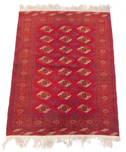 An Afghan Belouch type rug, with three rows of medallion on a red ground, with multiple borders, 138cm x 208cm.