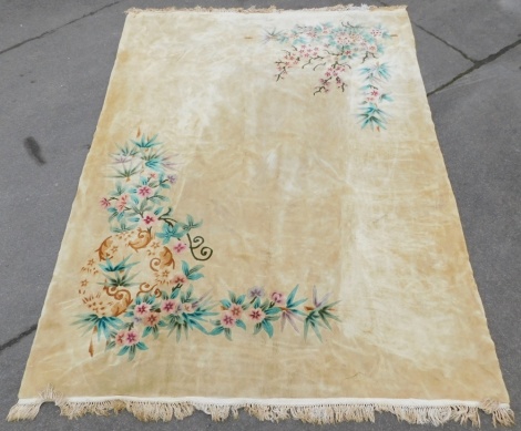 A Chinese cut wool rug, on a cream ground with pink flowers and leaves, with tassel ends, 390cm x 280cm.