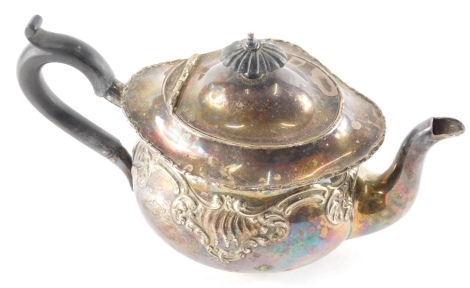 An early 20thC silver teapot, repousse decorated with scrolls, with an ebonised thumb mould handle and ebonised knop, marks rubbed, 14cm high, 10.6oz all in.