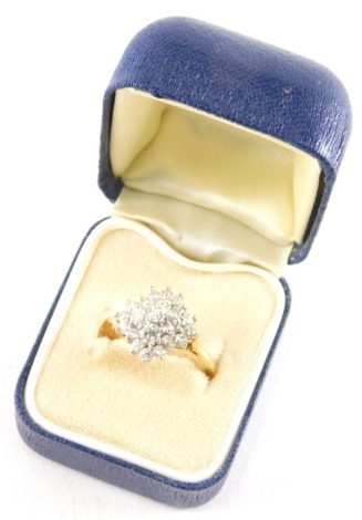 An 18ct gold and diamond ladies floral cluster ring, set with twenty one diamonds, size M.