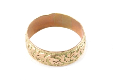 A 9ct gold band, with raised decoration of flowers, size V, 3.8g.