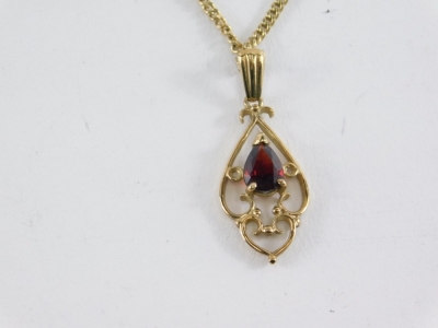 An Art Nouveau garnet pendant, 2cm high, with pierced setting attached to a slender link chain, 4.2g all in. - 2