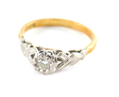 An 18ct gold diamond solitaire ring, with illusion set round brilliant cut diamond, totalling approximately 0.10ct, with V and heart splayed shoulders in white gold, on a yellow metal band, stamped 18ct, ring size N, 2.8g all in.