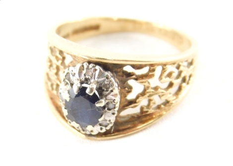 A 9ct gold dress ring, with central oval sapphire and diamond panel, on pierced abstract design shoulders, ring size N½, 4g all in, boxed.