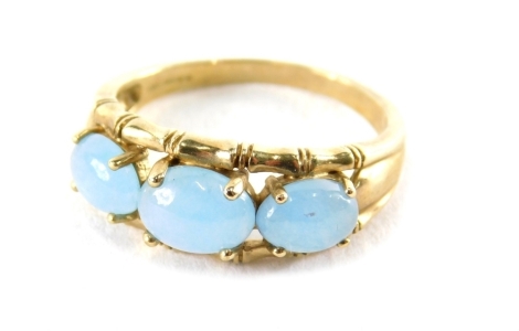 A 9ct gold three stone dress ring, with three polished cabochon pale blue stones, bamboo outer work setting, ring size R, 3.6g all in.