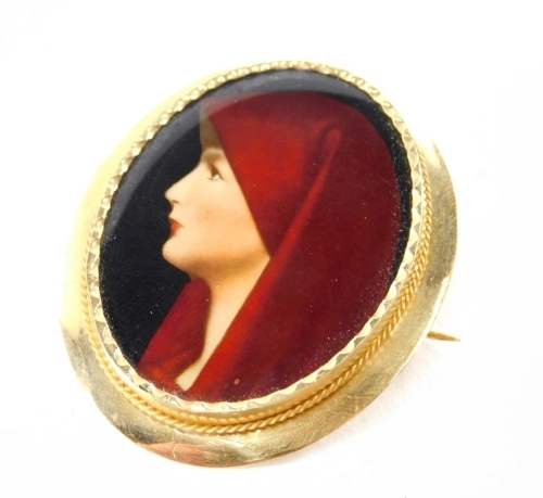 A painted porcelain Austrian style brooch, oval depicting a lady in red headdress, in a yellow metal setting with applied badge stamped c18 with plated main frame, 4 x 4½cm, 9.7g all in.