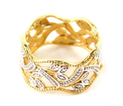 A modern dress ring, with outer wave design and applied floral detailing with white and yellow colourings, white metal stamped 925, ring size P½, 3.7g all in.