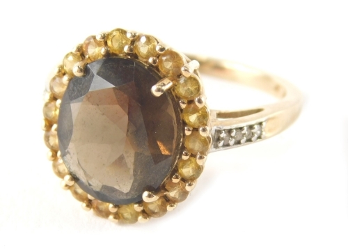 A 9ct gold smoky quartz citrine and cz set dress ring, the cluster with central oval smoky quartz surrounded by round brilliant cut citrines on a raised basket with cz set shoulders, ring size N½, 3.6g all in.
