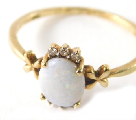 A 9ct gold opal and diamond dress ring, the oval opal in four claw setting with six tiny diamonds, and X set shoulders, ring size U, 2.2g all in, boxed.