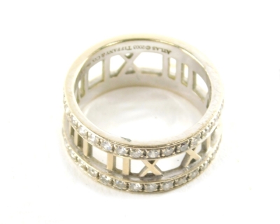 A Tiffany Atlas ring, set with small white stones, partially pierced with Roman numerals, marked Atlas 2003, Tiffany & Co 750 Italy, size P, 7.3g all in.