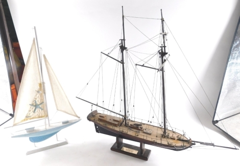 A painted model of a ship, with realistic rigging and deck, and a further painted yacht on wooden stand, 59cm high.