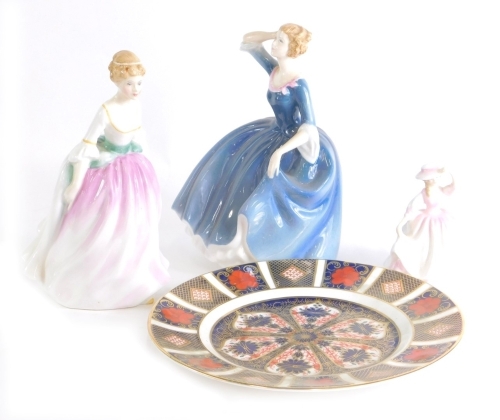 Three Royal Doulton porcelain figurines, Alison, Tina and a small figure Buttercup, and a Royal Crown Derby Imari pattern side plate, 21cm diameter. (4)