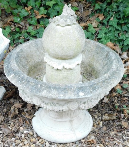 A composition stone fountain, of urn form decorated with fruit, leaves, etc., with central finial, 60cm diameter.