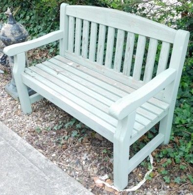 A green painted and slated garden bench, 123cm wide.