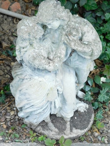 A composition stone statue, model in the form of male and female lovers on a circular base, 70cm high.