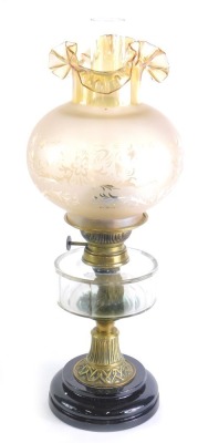 A Victorian oil lamp, the later opaque frosted shade decorated with scrolls and flowers, above a clear faceted glass reservoir, on a part reeded column with black ceramic base, 52cm high overall.