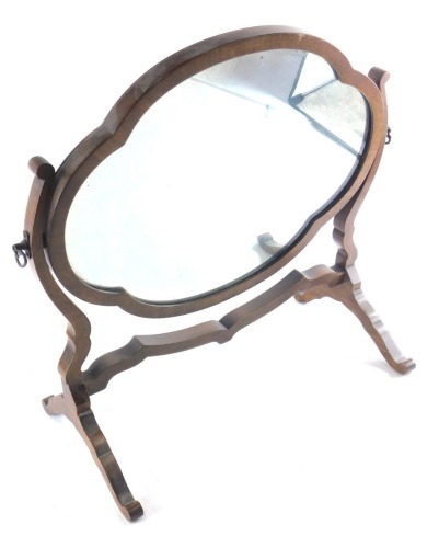 An early 20thC mahogany dressing table mirror, with lobed plate, on shaped supports and scroll feet, 51cm wide.