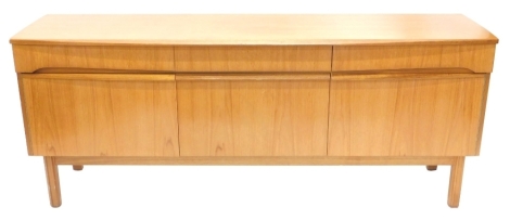 A 1960's/70's teak sideboard, with three frieze drawers above three drawers, each with piano hinges on square tapering legs, 184cm wide.