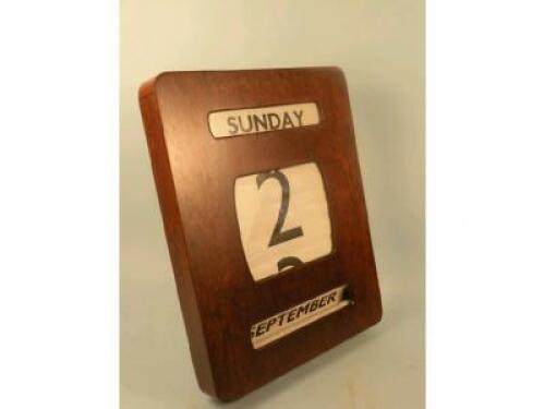 A teak and chrome office wall calendar of rectangular form with rounded corners