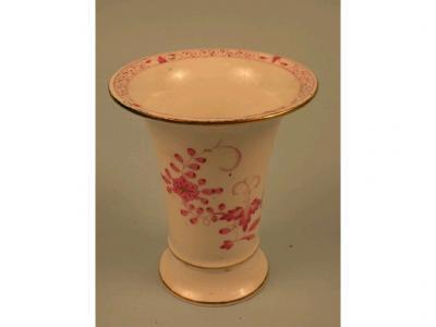 A porcelain tapering cylindrical vase decorated in pink with flowers and with gilt bands