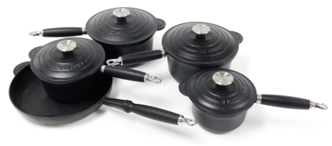 Four Le Creuset cast iron saucepans, 22cm diameter, 20cm diameter, 18cm diameter and a Le Creuset black iron frying pan.