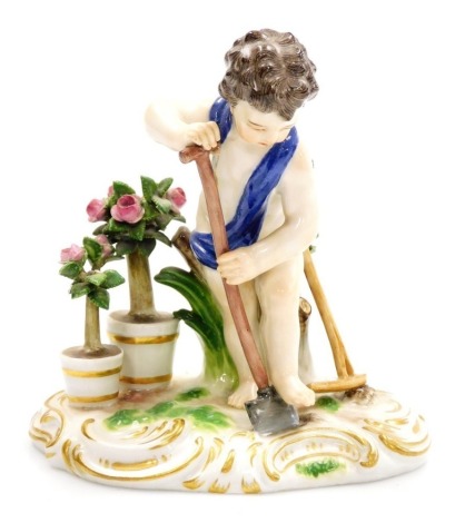 A late 19thC Meissen porcelain figure modelled as a putto, gardening with a spade and hoe beside standard roses, on a shaped oval rococo style base, blue crossed swords mark, 11.5cm high. (AF)