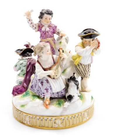 A late 19thC Meissen porcelain figure group, modelled as five children playing instruments and singing, and with a small dog seated at their feet, on a moulded circular base, in polychrome enamels, under glazed blue cross swords mark, 17cm high. (AF)