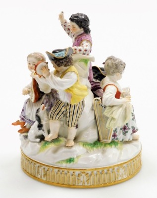 A late 19thC Meissen porcelain figure group, modelled as five children playing instruments and singing, and with a small dog seated at their feet, on a moulded circular base, in polychrome enamels, under glazed blue cross swords mark, 17cm high. (AF) - 2