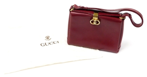 A vintage Gucci red leather top handle bag, with gold coloured double G turn lock clasp, the interior revealing three sections with additional coin purse, serial number 001-085-3050, 19cm high, 27cm wide, 10cm deep, ability to extend length of handle, wit