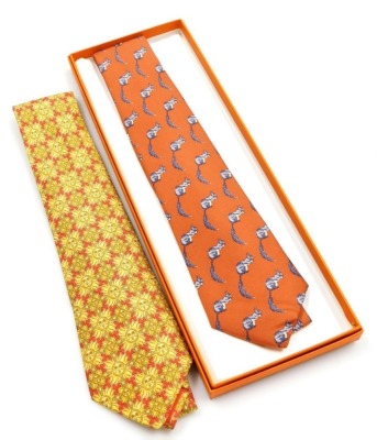 Two Hermes silk scarves, comprising a red tie decorated with yellow sunflowers, and a further red tie with squirrel design, one boxed.