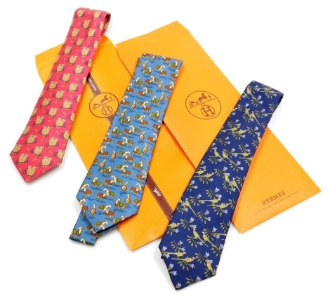 Three Hermes silk ties, comprising a blue tie decorated with pheasants, a further blue tie with horse design, and a red tie will over all design of two owls on a branch, with two Hermes sleeve cases.